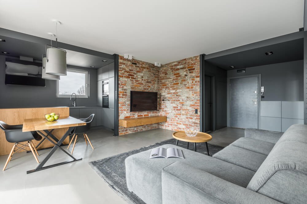 Sala de estar com 2 mesas, sofá luminárias, cozinha perto, um flat.