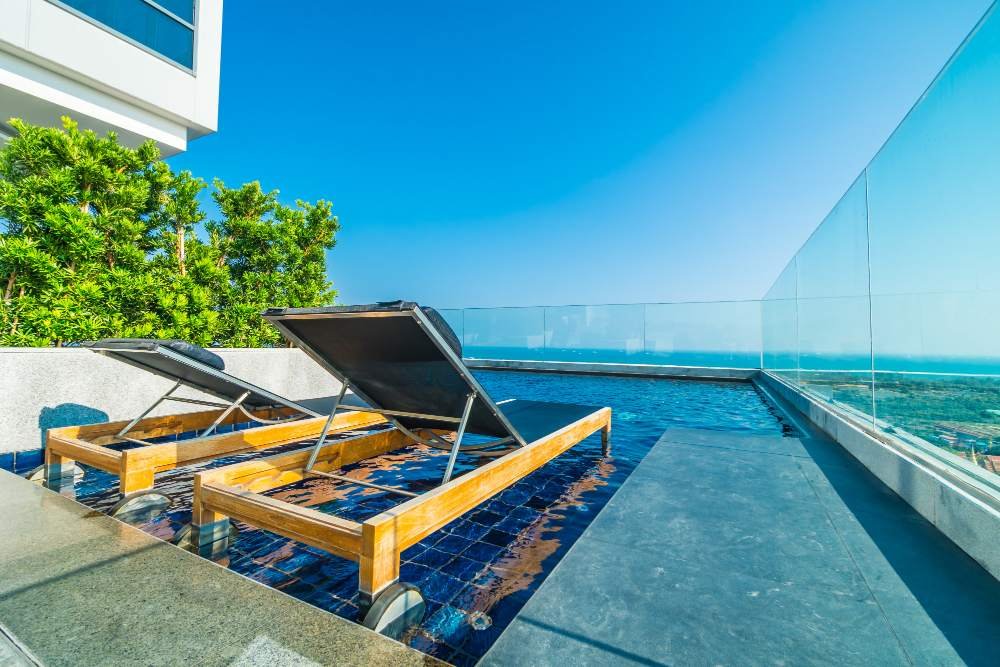 espreguiçadeiras em uma piscina na cobertura de um prédio de luxo