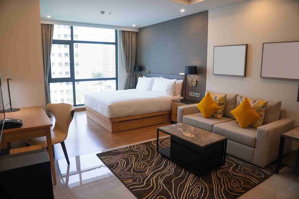 Quarto confortável de hotel em Moema com cama ampla e área de estar.